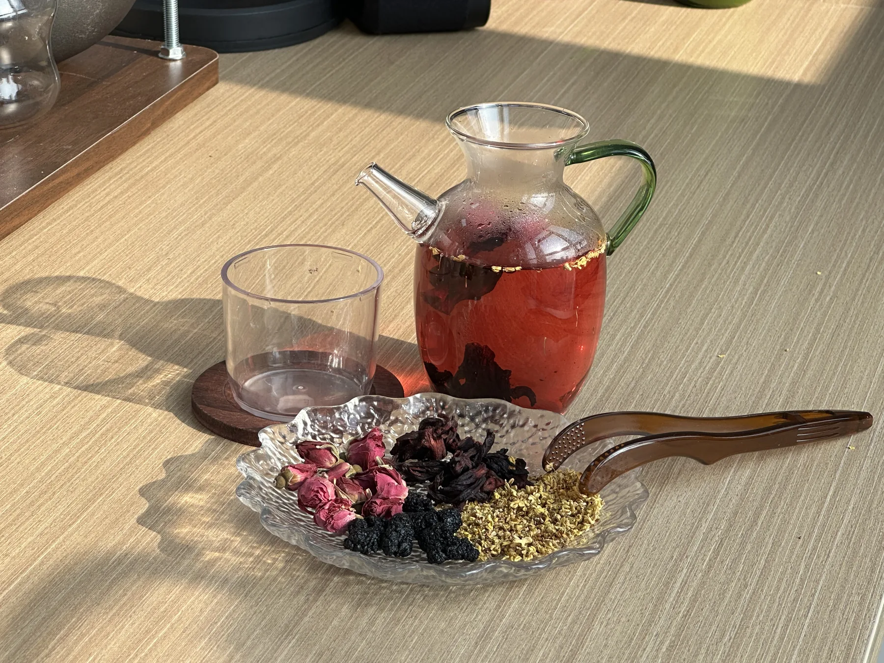 Osmanthus herbal tea with red infusion in a clear glass pitcher