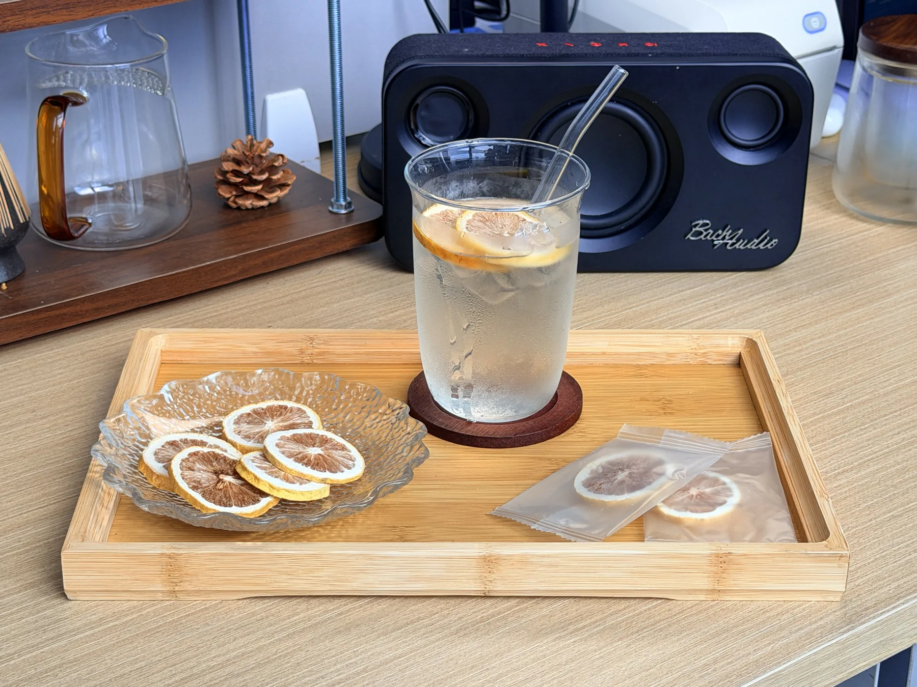 Clear glass of lemon infusion with freeze-dried lemon slices on a tray