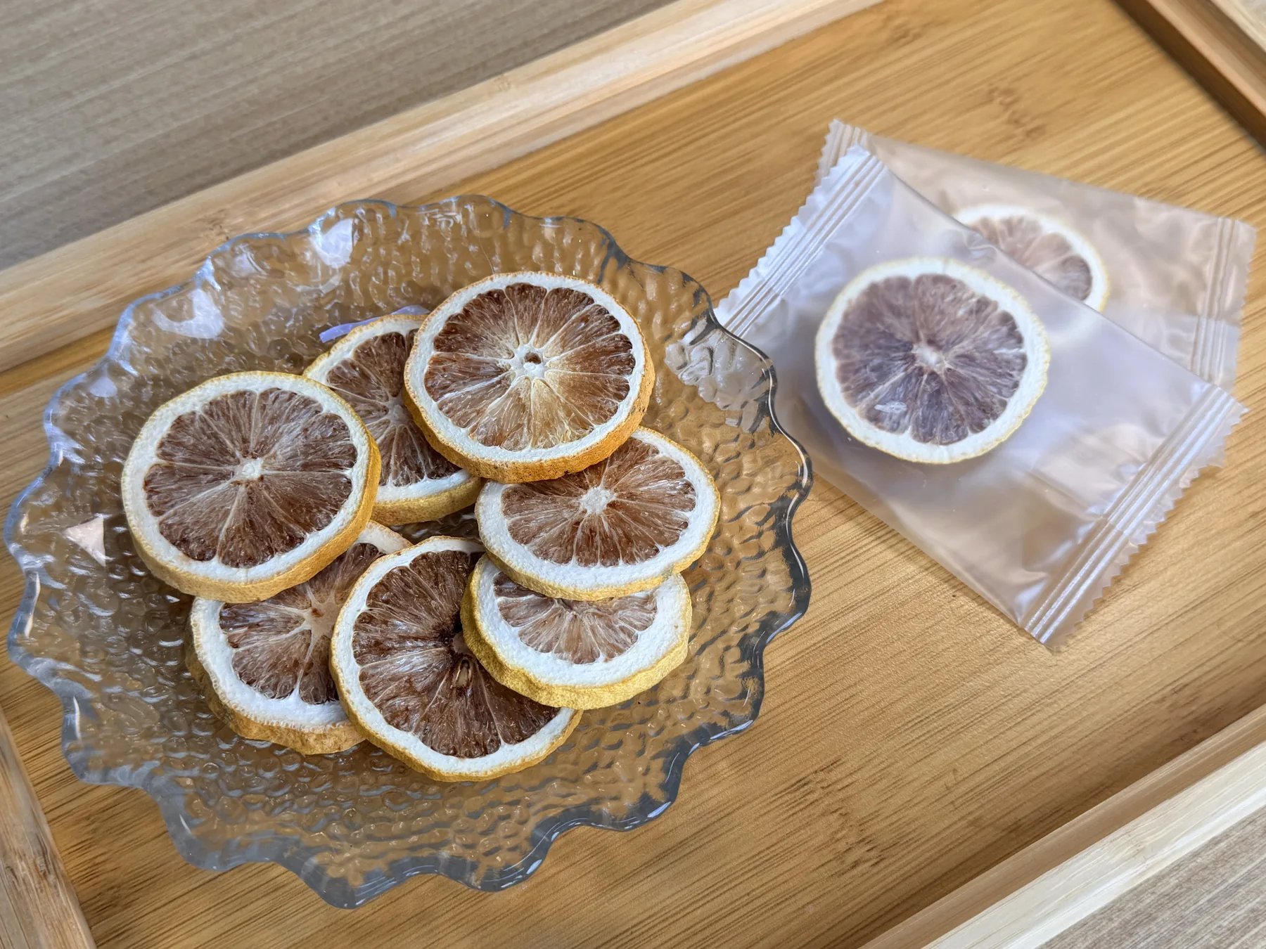 Freeze-dried lemon slices arranged on a glass plate with sample sachets nearby