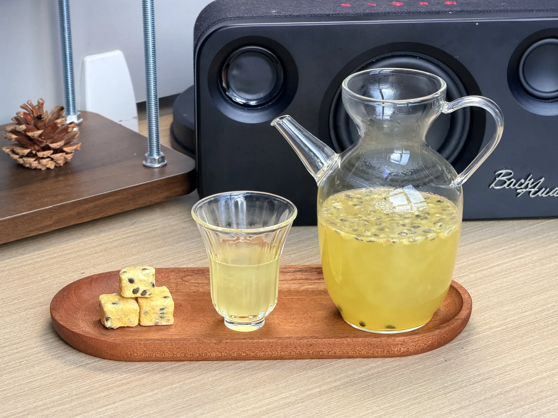 Passion fruit infusion in a clear pitcher with a serving glass
