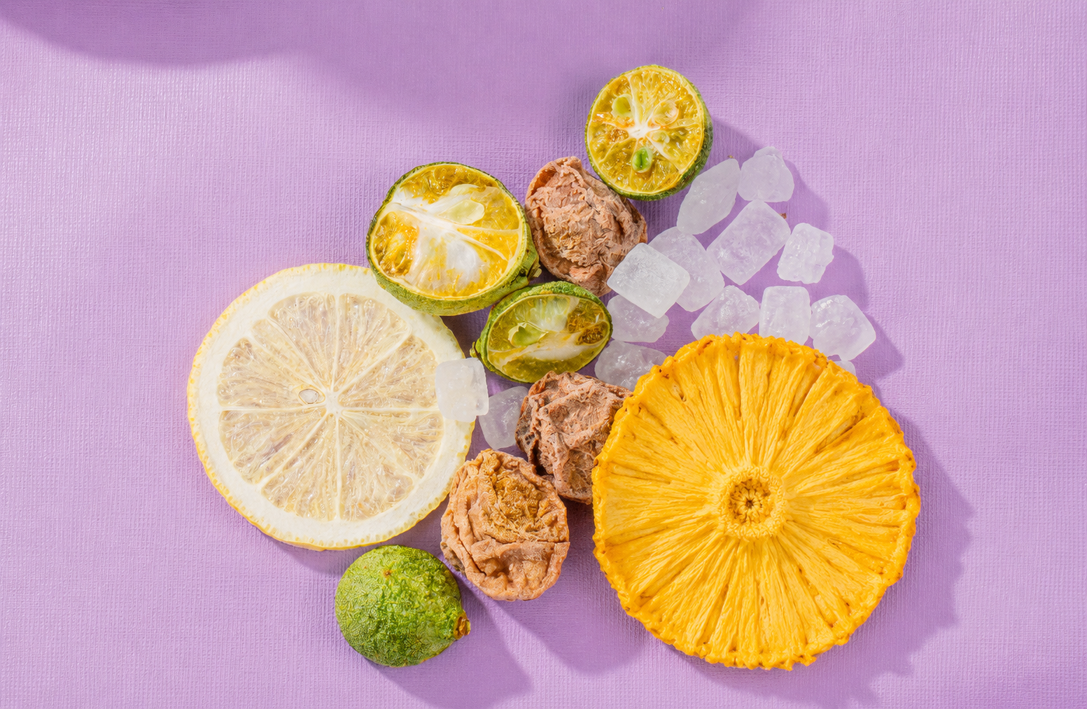 Dried pineapple, plum, lemon, and citrus pieces arranged for a pineapple plum lemon tea blend